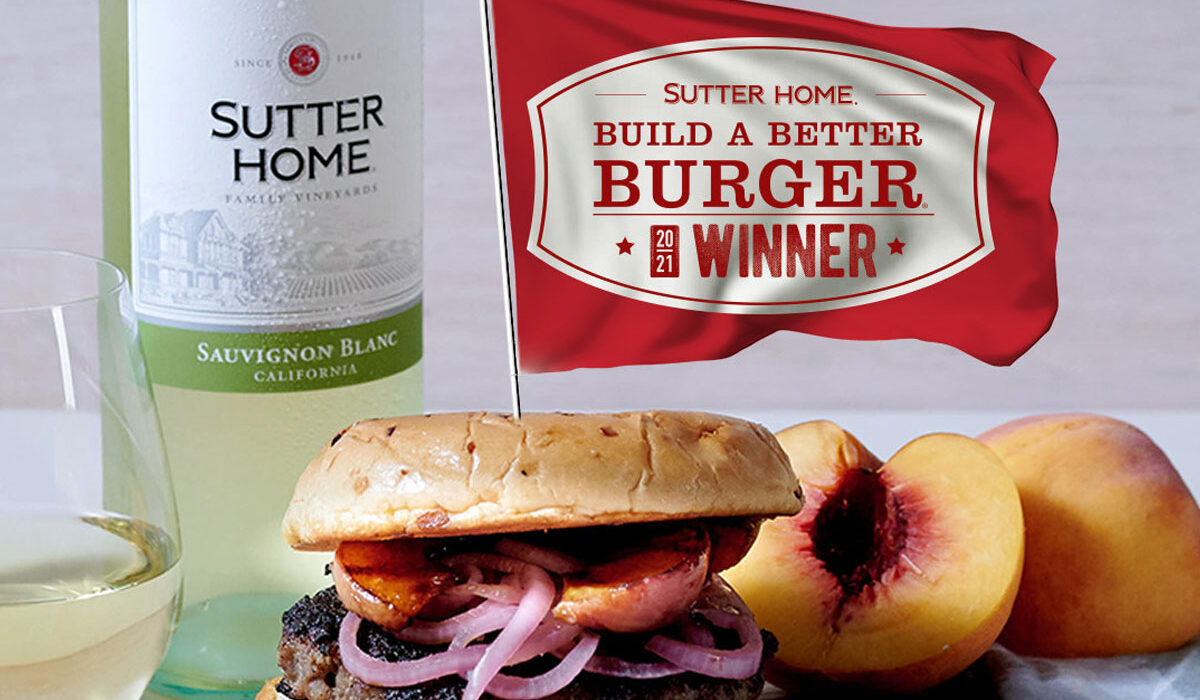 Color image of a hamburger in the forefront and a bottle Sutter Home Sauvignon Blanc and the Build a Better winner banner in the background.