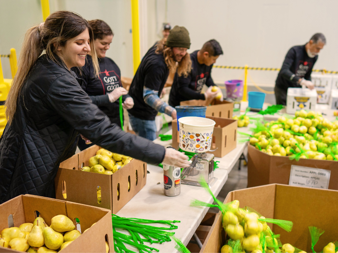 A group of men and women volunteering at a food back for the Gott for Good program