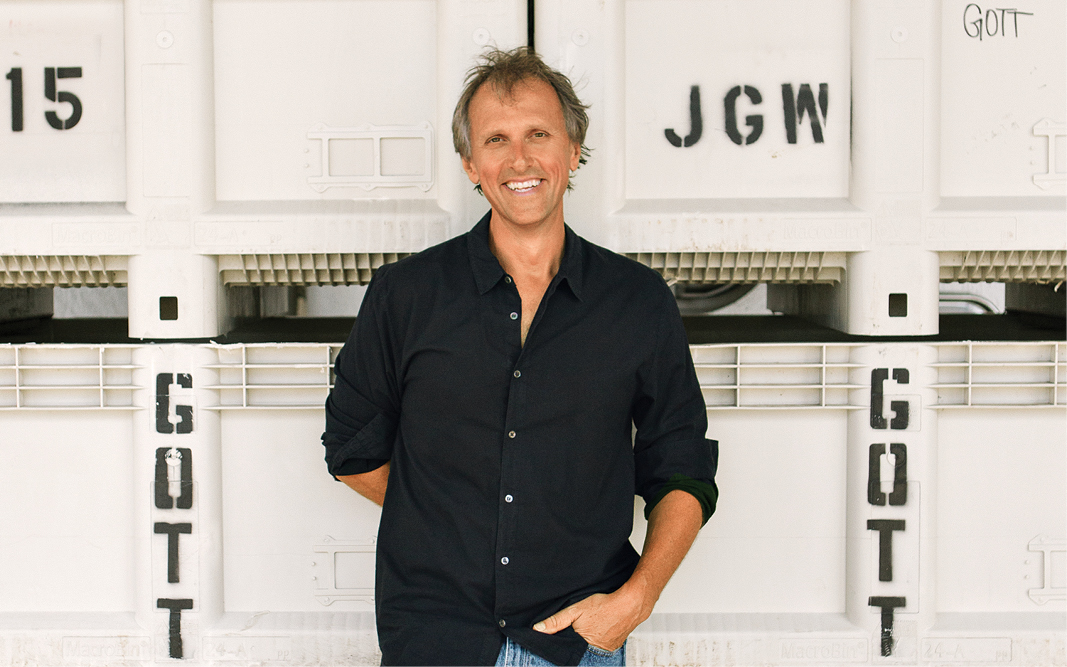Color image of Joel Gott standing in front of bins.